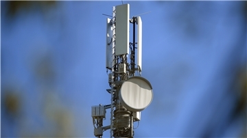 Ein Sendemast für Mobilfunk vor blauem Himmel.