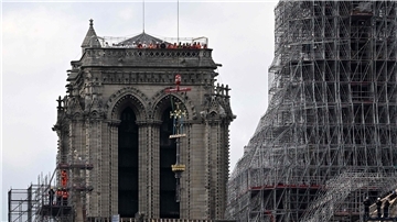 Das Kreuz der Kathedrale Notre-Dame wird während des Wiederaufbaus auf die neu errichteten Turmspitze gesetzt.