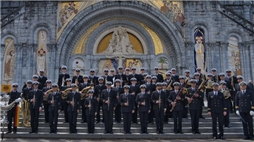 Das Marinemusikkorps Wilhelmshaven ist ein gern gesehener Gast bei Wohltätigkeitskonzerten. Musiker in Marineuniformen auf einer Treppe vor einem Kirchenportal.