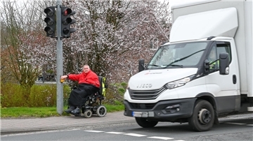 Mann im Rollstuhl an der Ampel