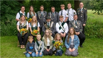 Kinder und Erwachsene posieren für ein Gruppenfoto.