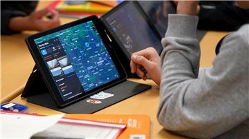 Kind nutzt Tablet im Unterricht