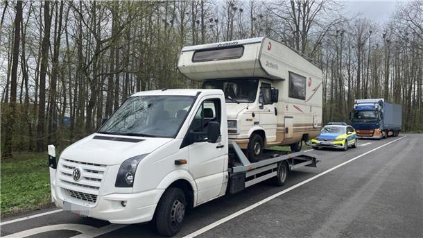Transporter mit Wohnmobil auf der Ladefläche