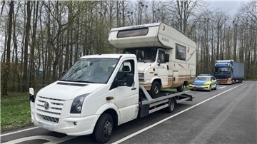 Transporter mit Wohnmobil auf der Ladefläche