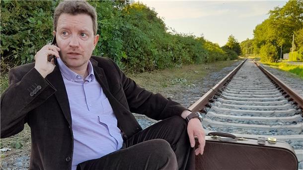 Ein Mann sitzt auf Gleisen und telefoniert mit einem Handy. Das piccolo teatro Haventheater zeigt "Nächste Station: Abenteuer". In dieser Uraufführung spielt Stefan Wilde die Rolle des Amadeus. 