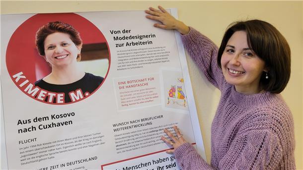 Erfolgreich zugewandert: Caritas zeigt Film über Migranten in Cuxhaven Das Projekt "Erfolgreich eingewandert" des Caritasverbandes für Bremen-Nord umfasst auch eine Plakatausstellung. Mitarbeiterin Yuliya Kamp präsentiert eine der Protagonistinnen, die auch im gleichnamigen Doku-Filmprojekt ihre Geschichte erzählen. Kamp selbst gehört auch dazu.