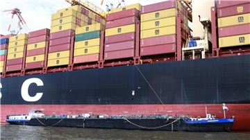Das Tankschiff „Weser-Service“ liegt unter der Bordwand eines Containerriesen im Hafen. Die Crew entsorgt Altöl und sorgt dafür, dass die großen Schiffe auf der Weser fahrbereit bleiben.