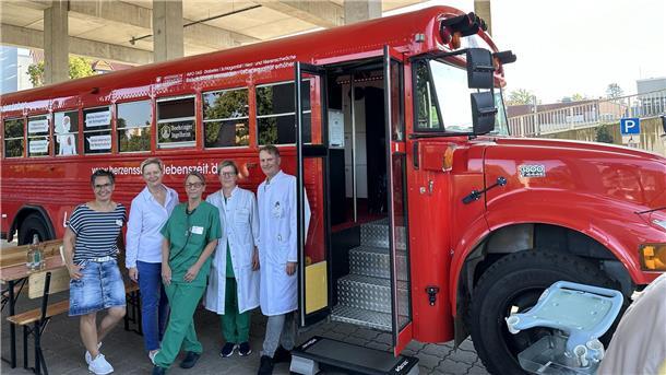 Ärzte in weißen Kitteln vor einem roten Fahrzeug: Das Team des Agaplesion Diakonieklinikums Rotenburg freut sich auf viele  Besucher: Der rote Info-Bus „Herzenssache Lebenszeit“ macht am 10. September in Rotenburg Halt. Fachärzte informieren kostenlos über Schlaganfall, Herz-Kreislauf-Erkrankungen und Diabetes. 