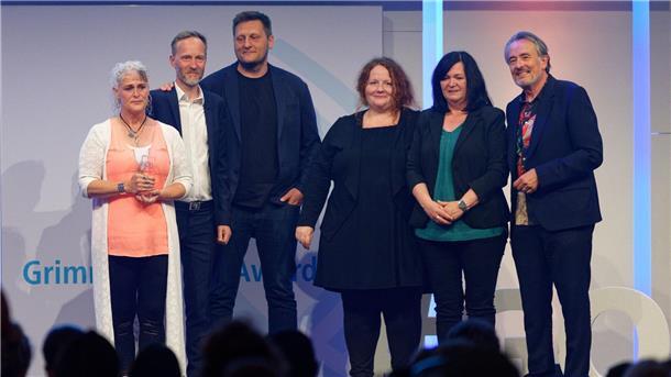 Grimme Online Award für historische Recherchen und mehr Das Team von „Im Takt: Wege in den Jugendhof Turgau“ steht bei der Verleihung des Grimme Online Award 2023 mit dem Preis in der Kategorie „Wissen und Bildung“ auf der Bühne.