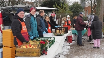 Das Team von „Pier 6“ und ehrenamtliche Helfer der Tafel bei der Ausgabe einer warmen Mahlzeit im Leher Stadtpark.