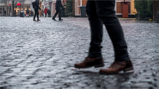 Glatteis: Deutschland rutscht in die Weihnachtswoche Das vereiste Kopfsteinpflaster auf dem Coburger Marktplatz macht es den Fußgängern schwer.