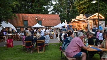 Menschen auf einem Hof zwischen Bäumen