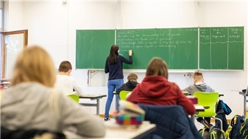 Schülerinnen und Schüler einer fünften Klasse sitzen während des Unterrichts in ihrem Klassenzimmer