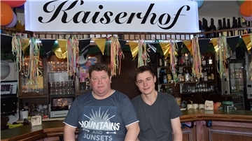 Zwei Männer vor einer Bar.