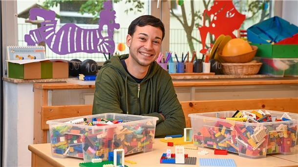 Spanischer Erzieher: Deshalb finde ich Bremerhaven super  Ein junger Erzieher hinter einem Tisch mit Lego-Steinen.