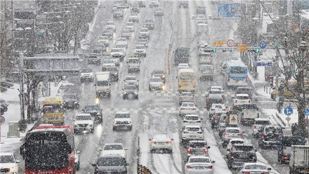 Tote und Verkehrschaos durch Kälte in Nordostasien Dei starkem Schneefall drängen sich Fahrzeuge dicht an dicht auf einer Straße im südkoreanischen Suwon.