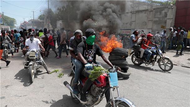 Demonstranten fahren mit ihren Motorrädern an einer brennenden Barrikade vorbei, während sie gegen die Unsicherheit in Port-au-Prince protestieren.