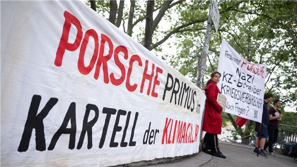 Porsche mit turbulenter Hauptversammlung Demonstranten mit Plakaten vor Beginn der Porsche-Hauptversammlung in Stuttgart.