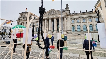 Demonstranten stehen mit symbolischen Galgen vor dem Reichstag und demonstrieren gegen Hinrichtungen und die Todesstrafe im Iran.