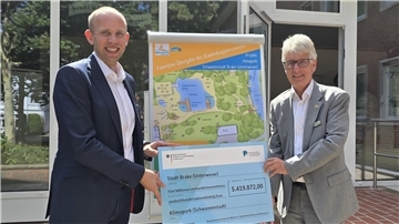 Bild von Dennis Rohde, Parlamentarischer Staatssekretär beim Bundesfinanzminister, und Brakes Bürgermeister Michael Kurz bei der Übergabe des Förderbescheids für das Projekt Schwammstadt Brake