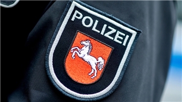 Es ist der Arm eines Polizisten mit dem Niedersachsen-Wappen zu sehen.