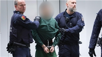 Der Angeklagte Ibrahim A. wird von Justizbeamten an seinen Platz im Gerichtssaal gebracht.