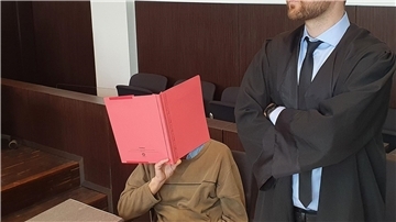 Der Angeklagte (l) sitzt neben seinem Verteidiger Maximilian Klefenz im Verhandlungssaal des Düsseldorfer Landgerichts und verdeckt sein Gesicht.