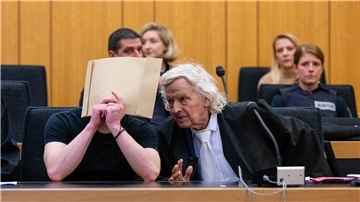 Der Angeklagte (l) sitzt zum Prozessauftakt im Landgericht Münster neben einem seiner Verteidiger.