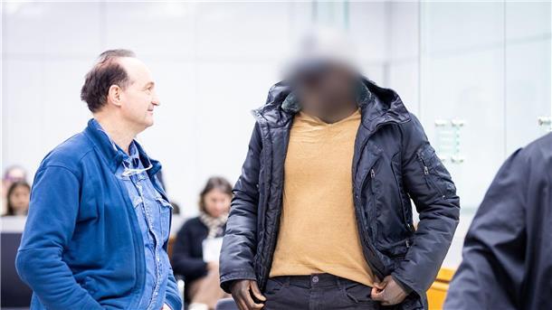 Ex-Soldat aus Gambia erhält in Celle lebenslange Haftstrafe Der Angeklagte (r) steht im Gerichtssaal.