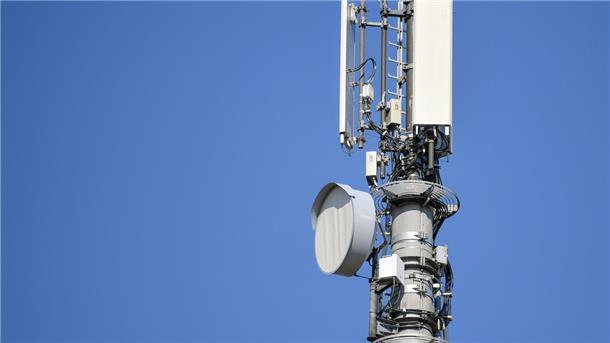 Ein Sendemast für Mobilfunk vor blauem Himmel.
