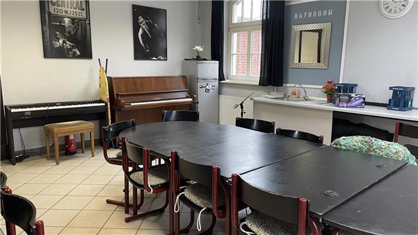 Raum mit Tisch und Klavier