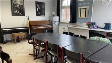 Raum mit Tisch und Klavier