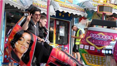 Zwei Menschen in einem Fahrgeschäft auf dem Freimarkt. 