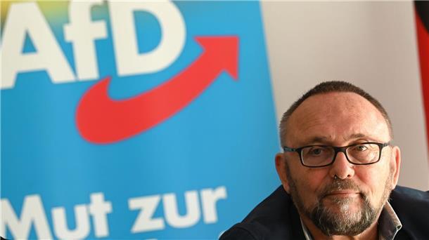 AfD-Politiker Frank Magnitz vor AfD-Fahne