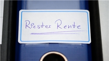 Ein blauer Ordner mit der Aufschrift "Riester-Rente" steht in einem Regal. Die Banken verlangen von Kunden Kosten, die vom Bundesgerichtshof untersagt worden sind. 