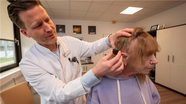 Der Chefarzt der HNO-Klinik am Klinikum Reinkenheide, Dr. Jörg Ebmeyer, erklärt seiner kürzlich operierten Patientin Uschi Rutka, wie ihr zweiteiliges und zum Teil unter die Kopfhaut implantiertes Hörgerät funktioniert.
