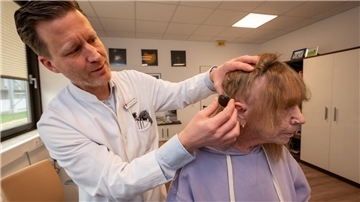 Der Chefarzt der HNO-Klinik am Klinikum Reinkenheide, Dr. Jörg Ebmeyer, erklärt seiner kürzlich operierten Patientin Uschi Rutka, wie ihr zweiteiliges und zum Teil unter die Kopfhaut implantiertes Hörgerät funktioniert.