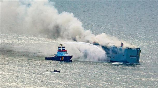 Auto-Frachter brennt vor Küste - Umweltkatastrophe droht Der Frachter „Fremantle Highway“ steht in Flammen. Ein Notschlepper (l) bekämpft das Feuer.