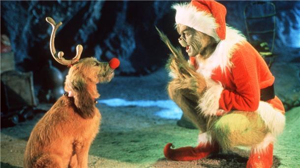 Der Grinch sitzt vor einem Hund.