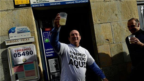 Der Inhaber einer Lotterieannahmestelle in Pamplona feiert nach dem Verkauf des Hauptgewinns.