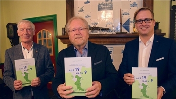 Drei Männer halten je ein Buch in den Händen