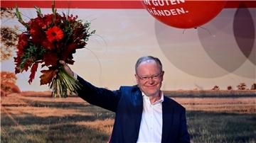 Ministerpräsident Weil mit Blumen.