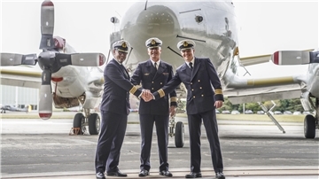 Drei Männer stehen vor einem Flugzeug