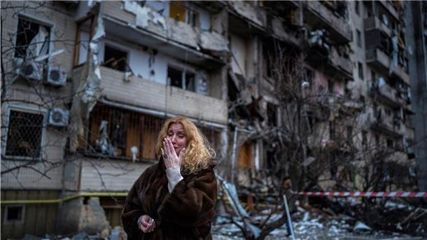 Migrationsexperte zum Krieg in der Ukraine: „EU muss Flüchtlinge aufnehmen“ Eine Frau reagiert neben ihrem Haus nach einem Raketenangriff in Kiew