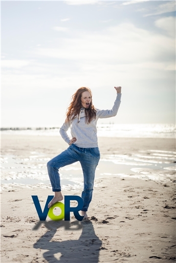 Eine Frau mit dem Logo der Kampagne „VoR - Vermeiden oder Recyceln“ am Strand