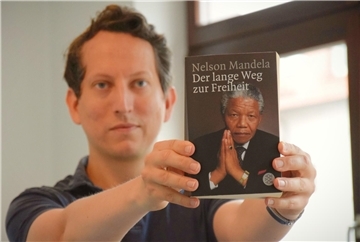 Ein Mann hält ein Buch in seinen Händen. 