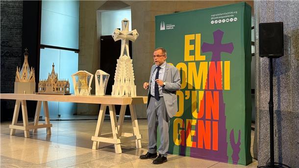 Kreuz aus Deutschland auf der Sagrada Familia vor Vollendung Der leitende Architekt der Sagrada Familia, Jordi Faulí, erklärt vor einem großen Poster den Aufbau des großen Kreuzes aus Deutschland für den Hauptturm der Basilika.