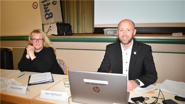 ein Mann und eine Frau sitzen nebeneinander an einem Tisch
