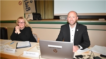 ein Mann und eine Frau sitzen nebeneinander an einem Tisch