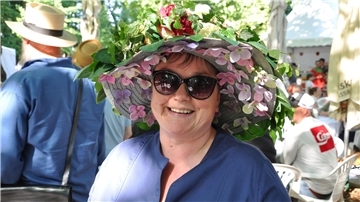 Frau mit bunt geschmücktem Hut bei der Landpartie Garten und Ambiente